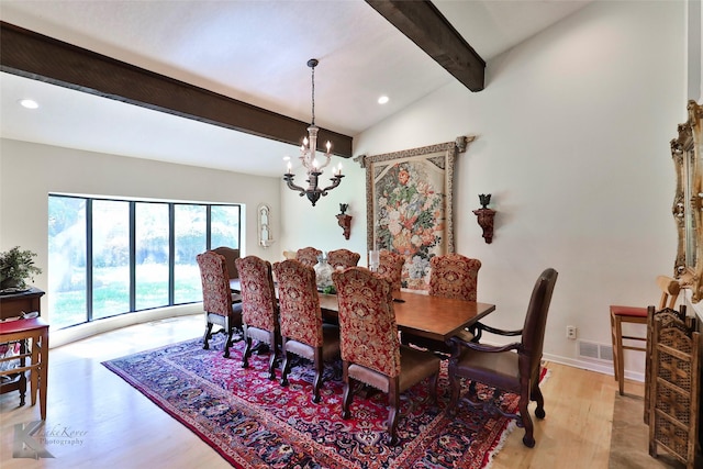 dining area featuring an inviting chandelier, vaulted ceiling with beams, and light hardwood / wood-style flooring