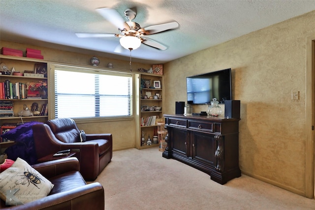 living room featuring ceiling fan, light colored carpet, and a textured ceiling