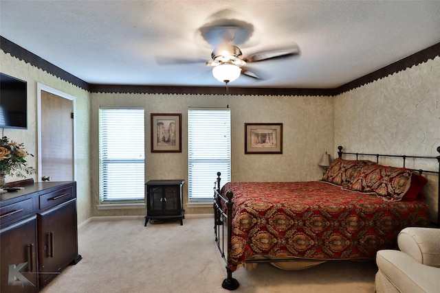 bedroom featuring ceiling fan, light carpet, and a textured ceiling