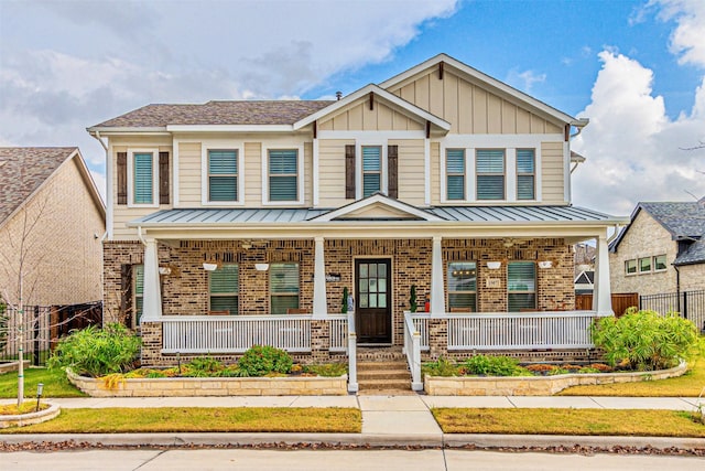 view of front of house featuring a porch, a standing seam roof, brick siding, and board and batten siding