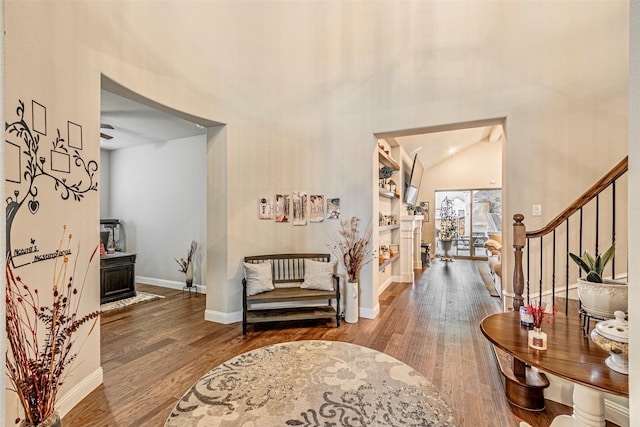 entryway with vaulted ceiling, stairway, wood finished floors, and baseboards