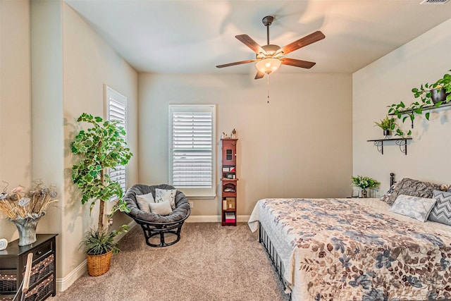 carpeted bedroom with a ceiling fan, visible vents, and baseboards