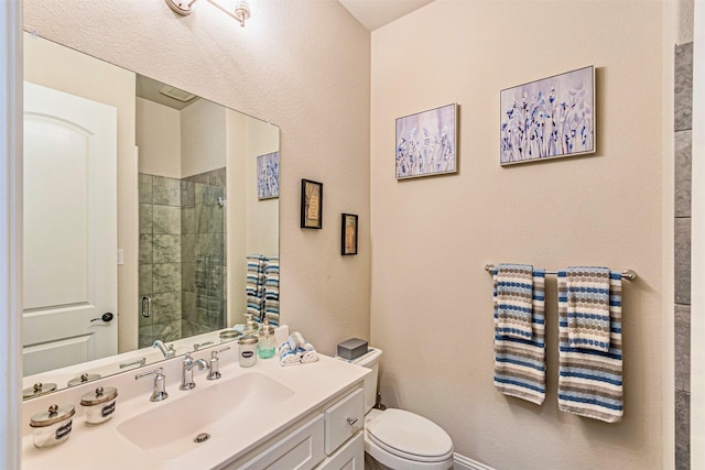 bathroom with a shower stall, toilet, and vanity