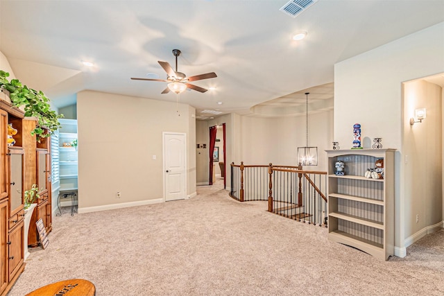 living area featuring ceiling fan with notable chandelier, an upstairs landing, light colored carpet, and visible vents