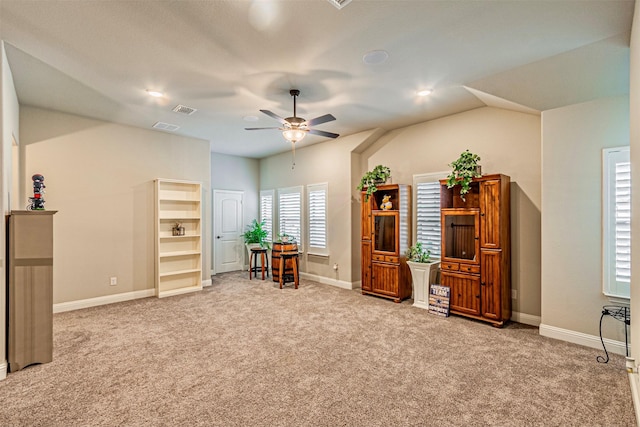 interior space featuring visible vents, baseboards, carpet, and a ceiling fan