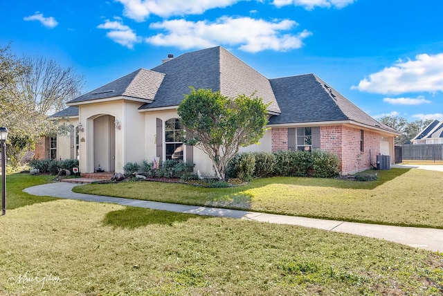 view of front of home with central AC, a front yard, and a garage