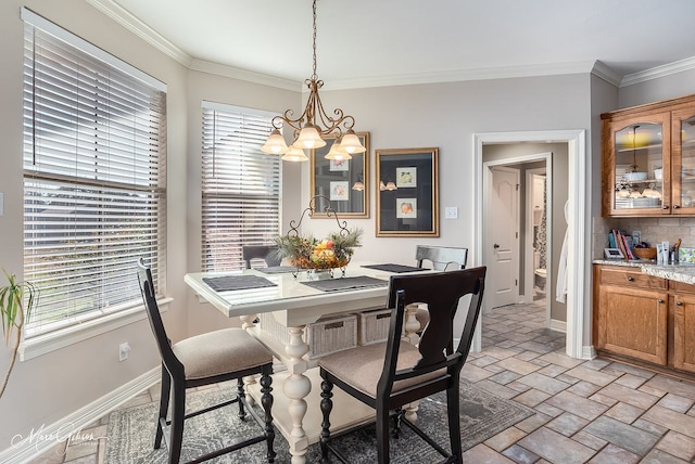 dining area with a notable chandelier, a wealth of natural light, and ornamental molding