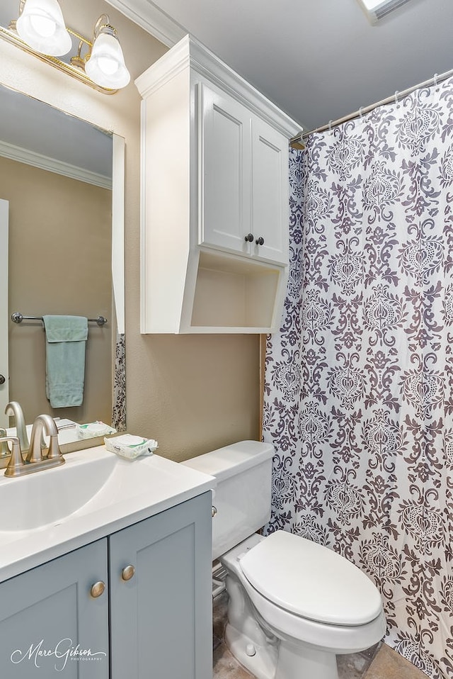 bathroom with ornamental molding, toilet, and vanity