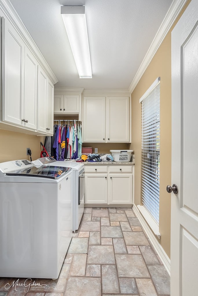 washroom with cabinets, crown molding, and separate washer and dryer