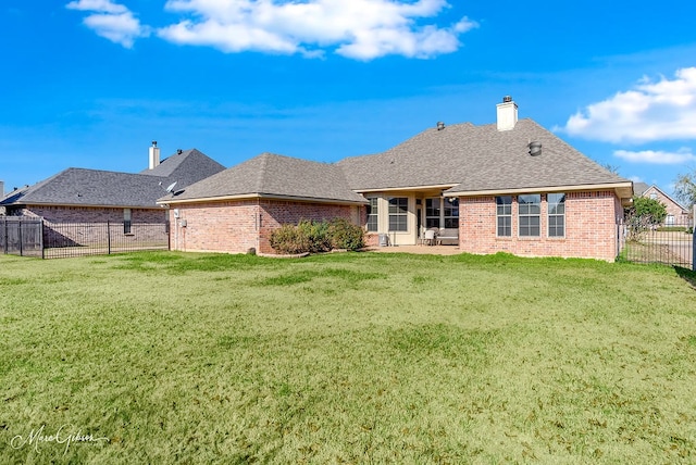 back of property with a yard and a patio area