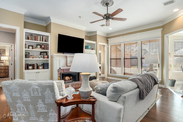 living room featuring a fireplace, ornamental molding, dark hardwood / wood-style floors, and ceiling fan