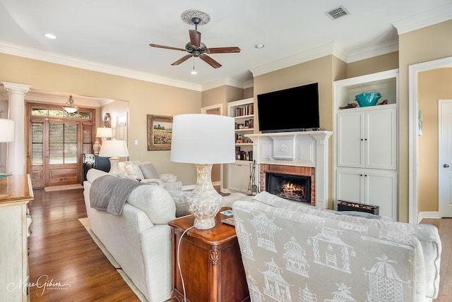 living room with ornamental molding, wood-type flooring, and a fireplace