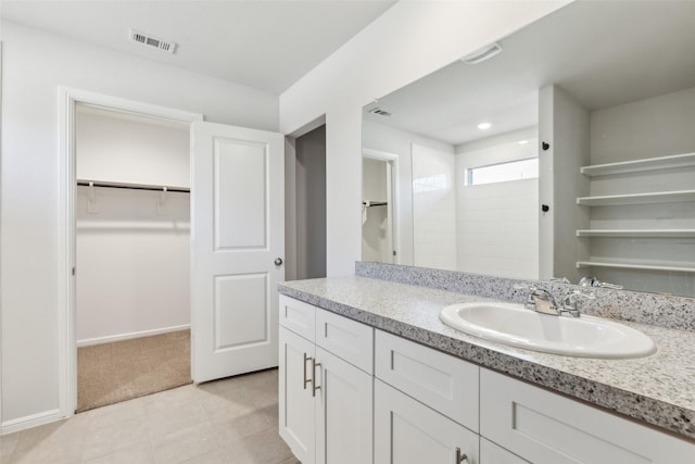 bathroom with a shower, vanity, and tile patterned floors