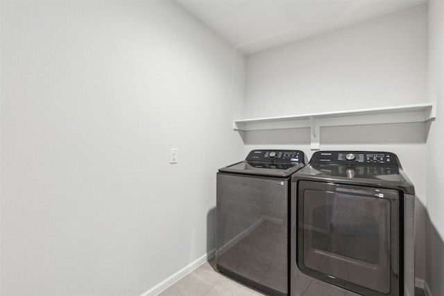 laundry area featuring light tile patterned flooring and washing machine and dryer