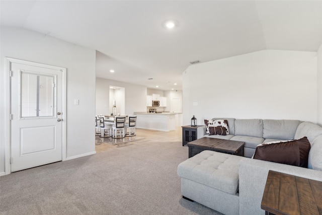 carpeted living room featuring lofted ceiling