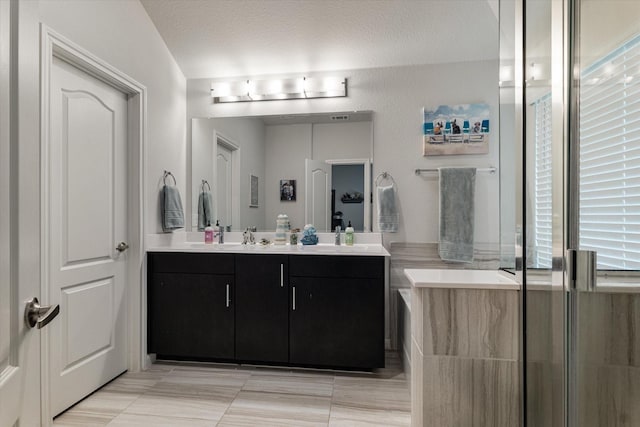 bathroom featuring vanity, a textured ceiling, and a wealth of natural light