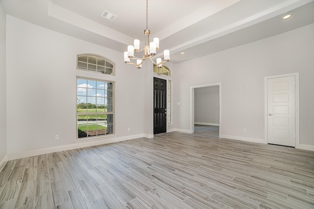 empty room with an inviting chandelier and light wood-type flooring