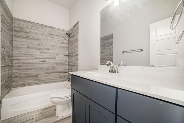 full bathroom featuring vanity, tiled shower / bath combo, and toilet