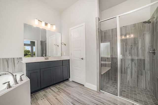 bathroom with vanity and shower with separate bathtub