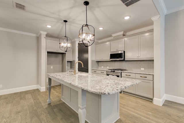 kitchen featuring light stone countertops, appliances with stainless steel finishes, backsplash, sink, and hanging light fixtures