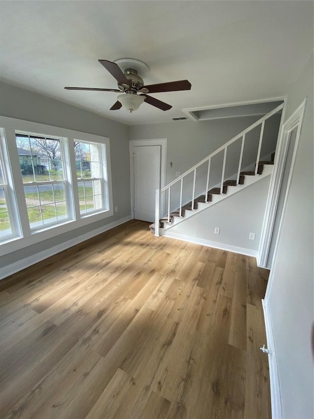 unfurnished living room with hardwood / wood-style floors and ceiling fan