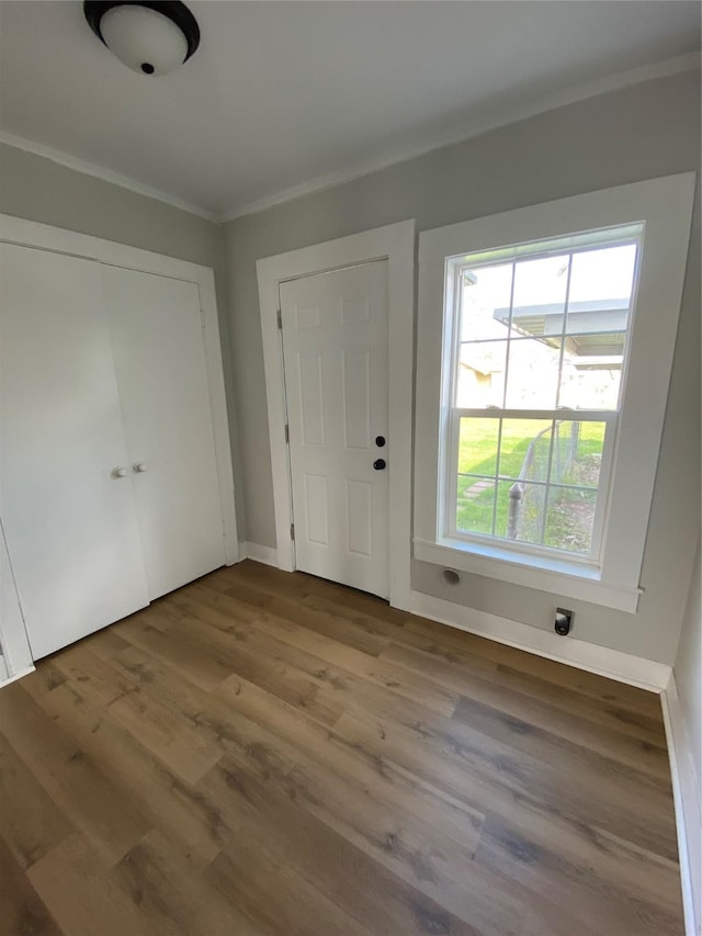 foyer with crown molding and light hardwood / wood-style flooring