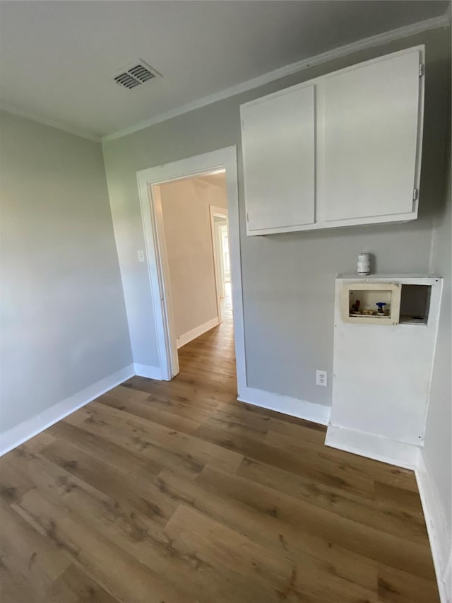 clothes washing area featuring washer hookup, cabinets, wood-type flooring, and crown molding