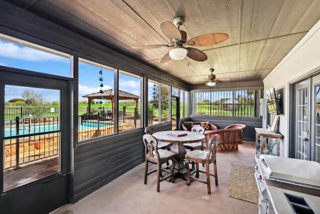 sunroom featuring wooden ceiling and ceiling fan