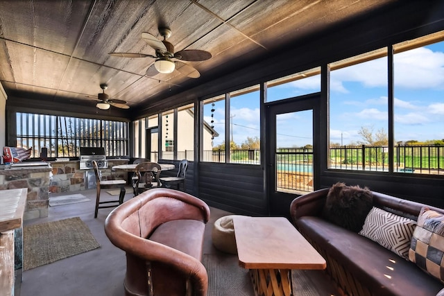 sunroom with wood ceiling and ceiling fan