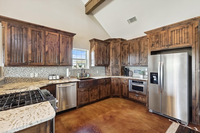 kitchen featuring sink, tasteful backsplash, stainless steel appliances, beam ceiling, and light stone countertops