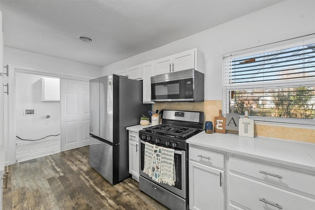 kitchen featuring stainless steel appliances, dark hardwood / wood-style floors, and white cabinets