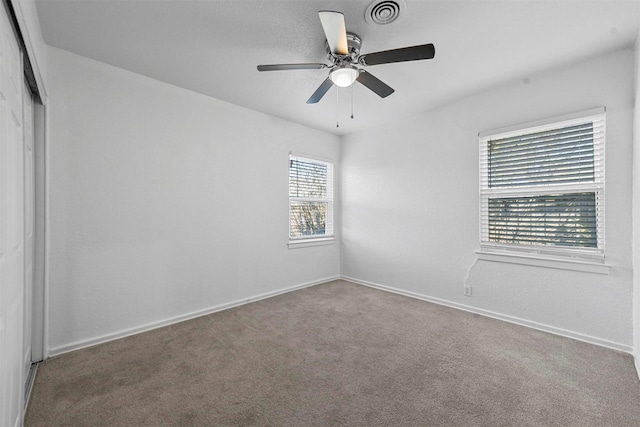 carpeted empty room featuring ceiling fan