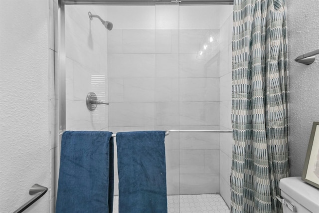 bathroom with tiled shower and toilet