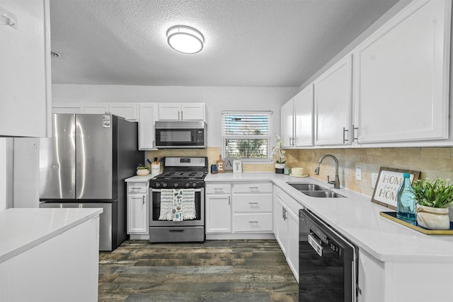 kitchen with decorative backsplash, stainless steel appliances, sink, white cabinets, and dark hardwood / wood-style floors