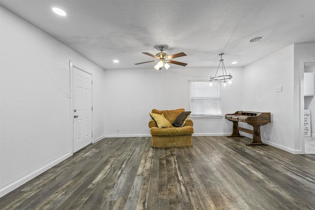 unfurnished room with ceiling fan, dark hardwood / wood-style floors, and a textured ceiling