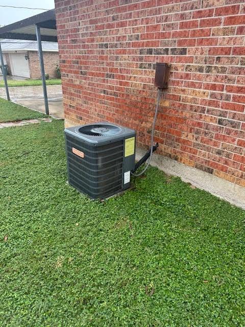 exterior details featuring cooling unit and brick siding