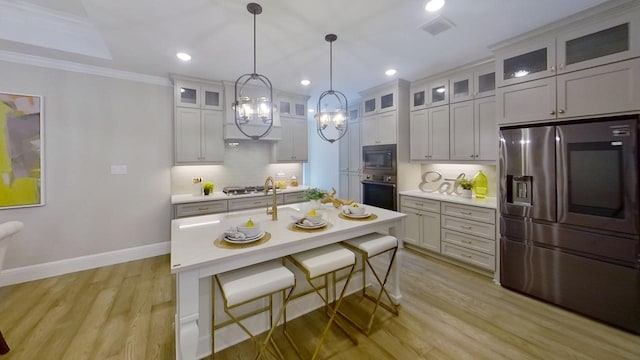 kitchen with hanging light fixtures, stainless steel appliances, light hardwood / wood-style flooring, backsplash, and crown molding