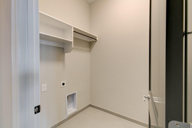 laundry area featuring hookup for an electric dryer and light tile patterned flooring