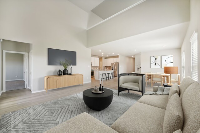 living room with a high ceiling and light hardwood / wood-style floors