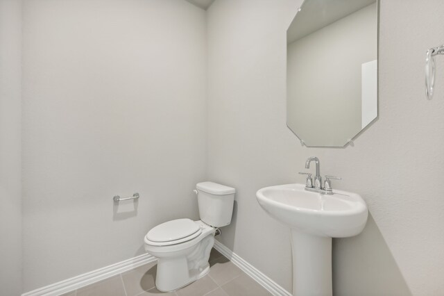 bathroom featuring tile patterned flooring, toilet, and sink