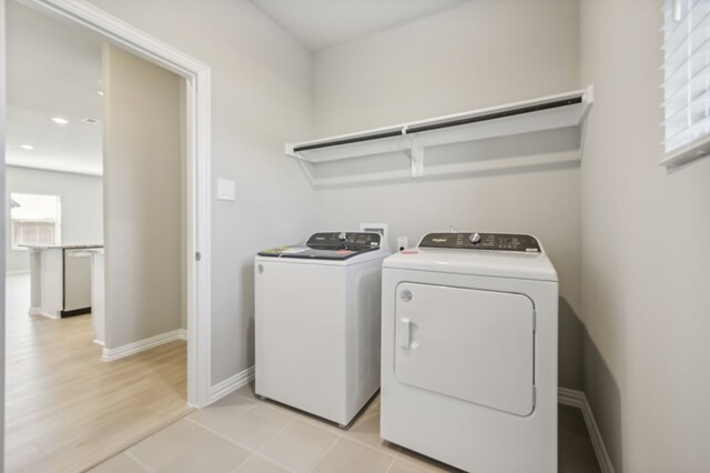 laundry room featuring washer and dryer and light hardwood / wood-style flooring