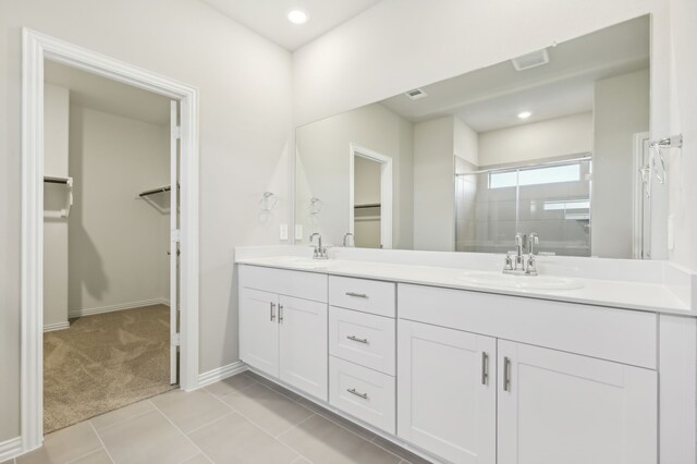 bathroom featuring tile patterned flooring, vanity, and an enclosed shower