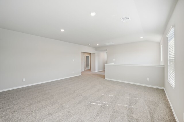 carpeted empty room featuring lofted ceiling