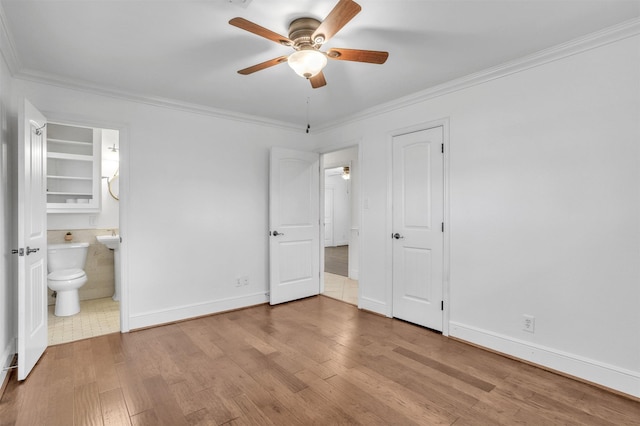 unfurnished bedroom with ceiling fan, light hardwood / wood-style floors, ornamental molding, and connected bathroom