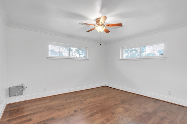 spare room with ornamental molding, dark wood-type flooring, ceiling fan, and a healthy amount of sunlight