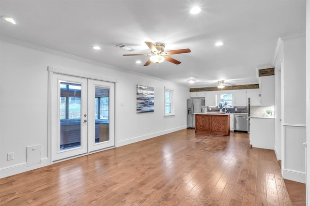 kitchen with french doors, white cabinets, light wood-type flooring, and appliances with stainless steel finishes