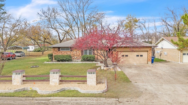 single story home with a front lawn, a carport, and a garage