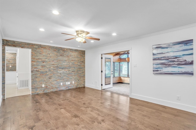 empty room with ceiling fan, wood-type flooring, and crown molding