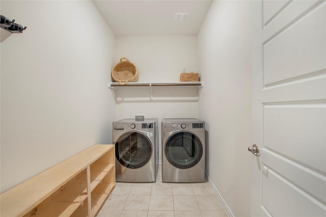 clothes washing area with independent washer and dryer and light tile patterned flooring