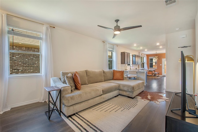 living room featuring ceiling fan, sink, and dark hardwood / wood-style floors